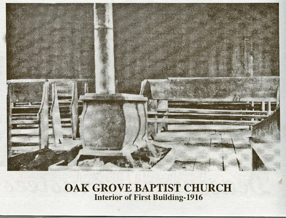 Interior of the first church building in 1916, with a wood stove and wooden pews
