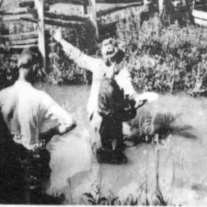 A baptism held outdoors in a creek