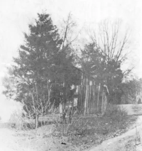 An early Oak Grove church building surrounded by trees